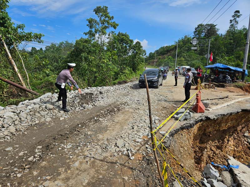 Personel Satlantas mengatur jalan lintas Riau-Sumbar Km 106-107 Kelok Indah Desa Tanjung Alai Kecamatan XIII Koto, Kabupaten Kampar.