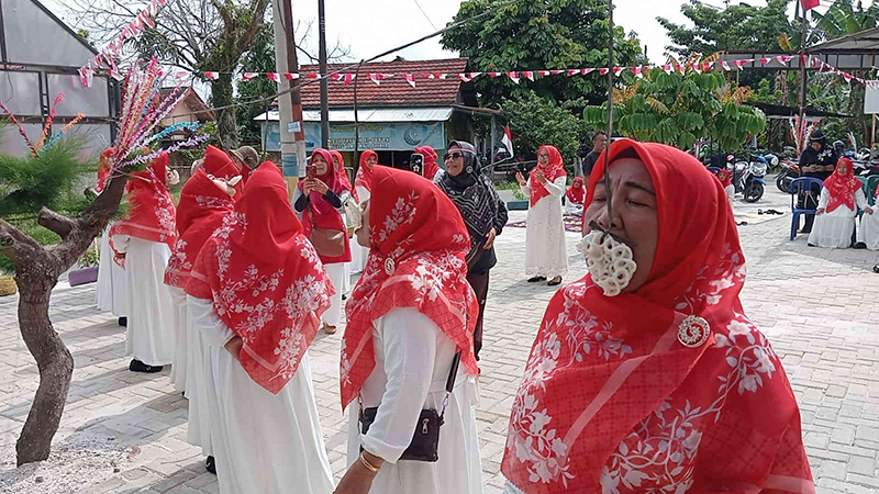 Para lansia antusias mengikuti perlombaan makan kerupuk saat peringatan Hari Kemerdekaan Republik Indonesia ke-79 dan HUT  ke-7 Kampung KB Berkah Bersama di Jalan Sei Mintan, Kelurahan Air Dingin.