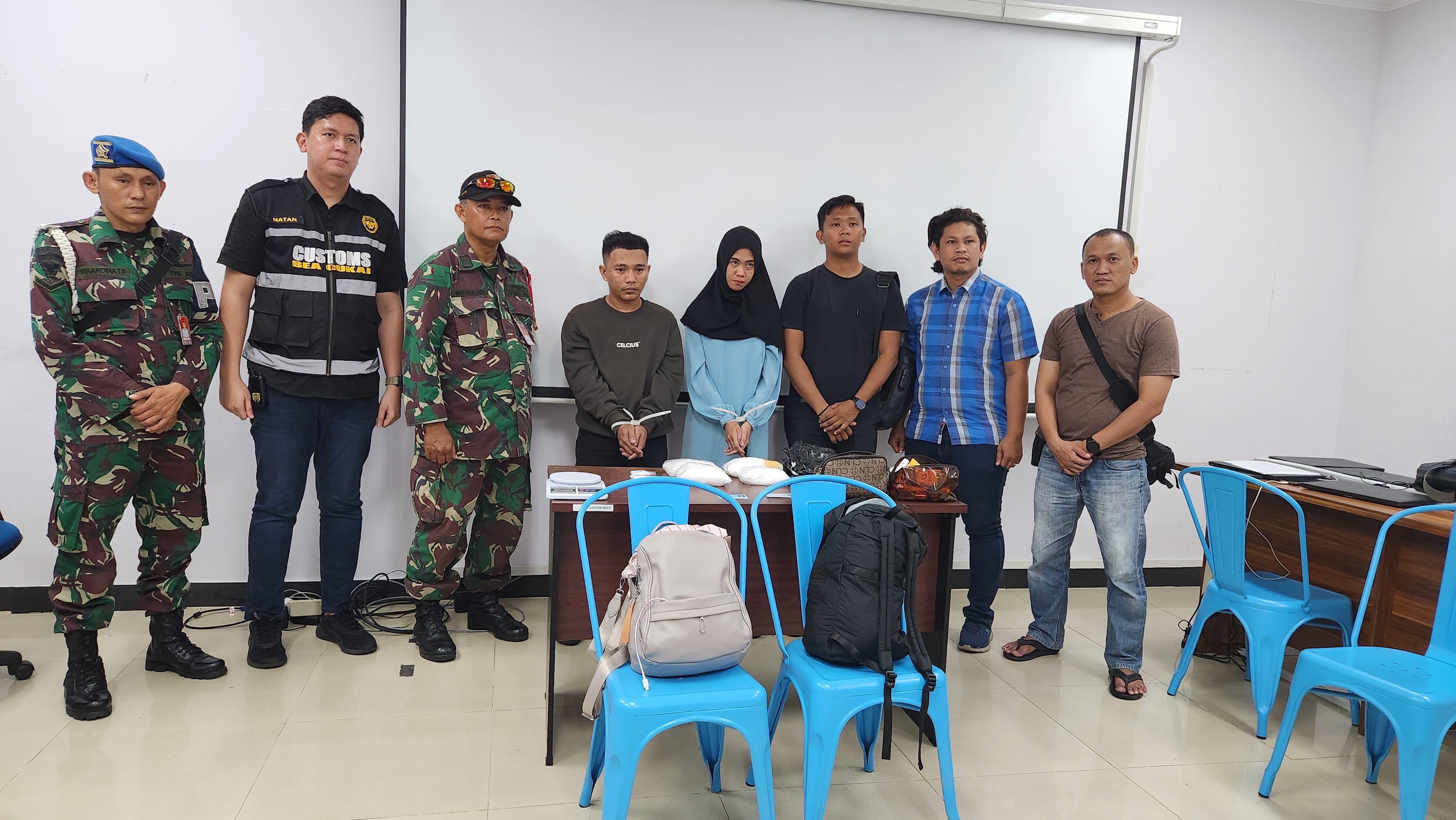 Petugas dari Avsec Bandara SSK II dan Subdit I Ditresnarkoba Polda Riau saat mengamankan dua pelaku penyelundup 2 kg narkotika jenis sabu, Kamis (22/8/2024).