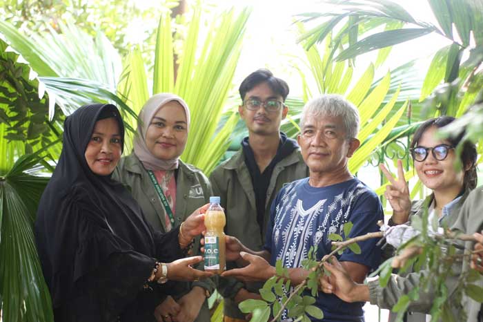 Mahasiswa KKN Kelompok 13   Umri bersama warga Tangkerang Laabuai menunjukkan Pupuk Organik Cair (POC) yang dihasilkan baru-baru ini.
