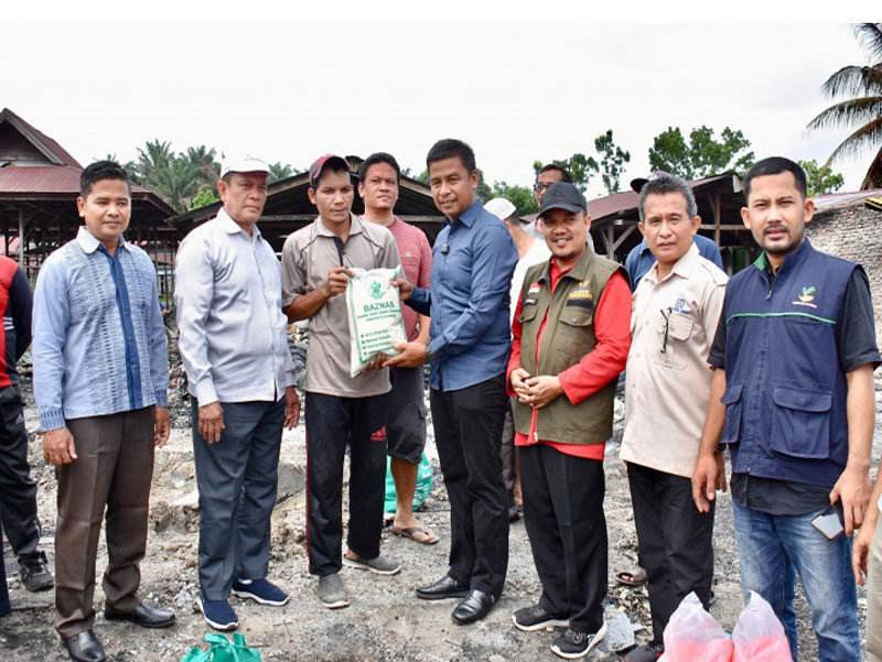 Pj Sekda Kampar Ahmad Yuzar menyerahkan bantuan kepada warga korban kebakaran di Desa Tapung Makmur Kecamatan Tapung Hilir, Kampar, Sabtu (24/8/2024).