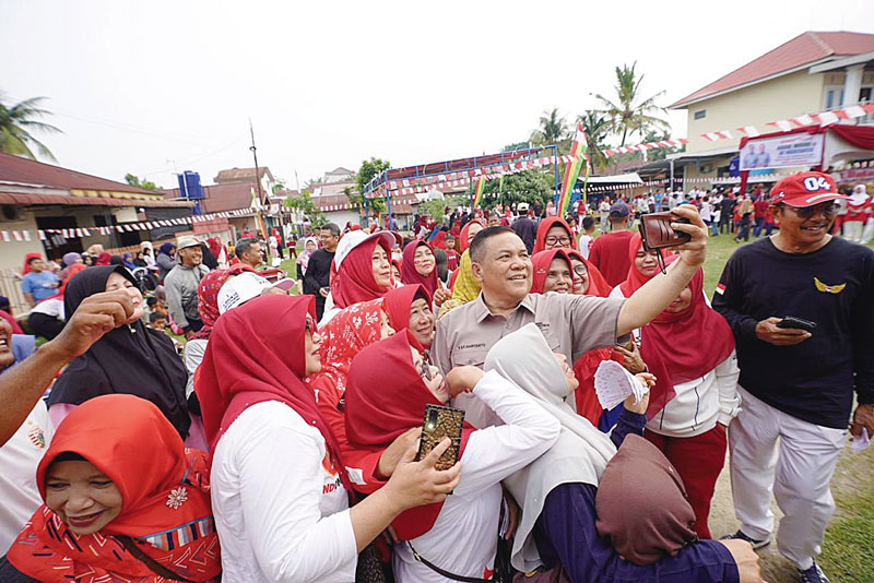 Sekdaprov Riau SF Hariyanto berswafoto bersama masyarakat saat menghadiri acara jalan santai di Pekanbaru, Ahad (25/8/2024).