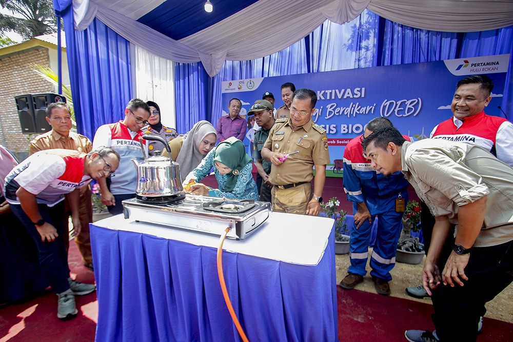 AKTIVASI DEB: Suramti menyalakan kompor biogas disaksikan Manager CSR PHR Pinto Budi Bowo Laksono (Tiga Kiri), Senior Officer CSR PHE Wahyu Irfan (Kiri),  Program Manager Biogas Rumah Yayasan Rumah Energi (YRE) Krisna Wijaya (Kanan) serta Camat Tapung Sof