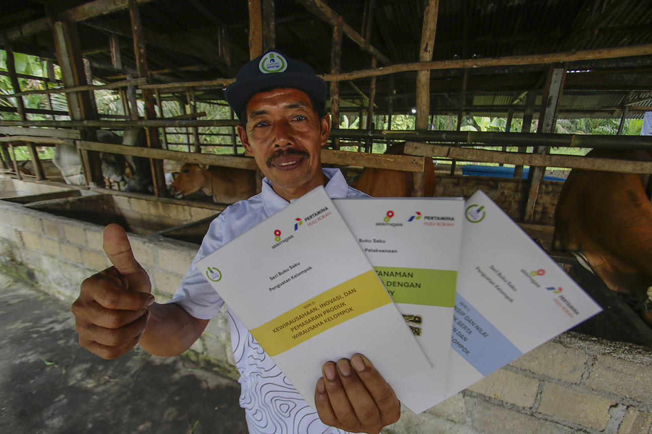 BUKU SAKU: Sudarman (52), penerima manfaat dari Kelompok Tani Bhina Muktisari memperlihatkan buku saku penguatan kelompok Program Desa Energi Berdikari berbasis Biogas yang merupakan program Tanggung Jawab Sosial Dan Lingkungan (TJSL) PHR, PHR bersama mit