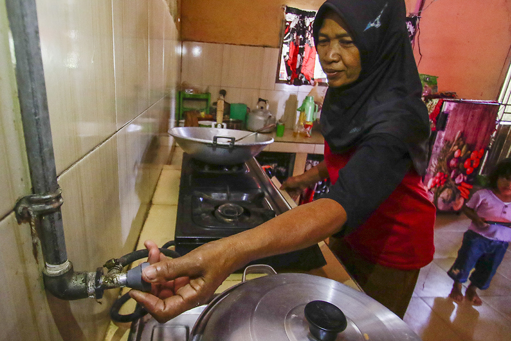 BUKA ALIRAN BIOGAS: Suramti, warga Desa Muktisari membuka aliran Biogas yang telah dialirkan dari reaktor, bisa segera dimanfaatkan untuk memasak di dapur rumah, Tapung, Kampar, Riau, Sabtu (6/7/2024).