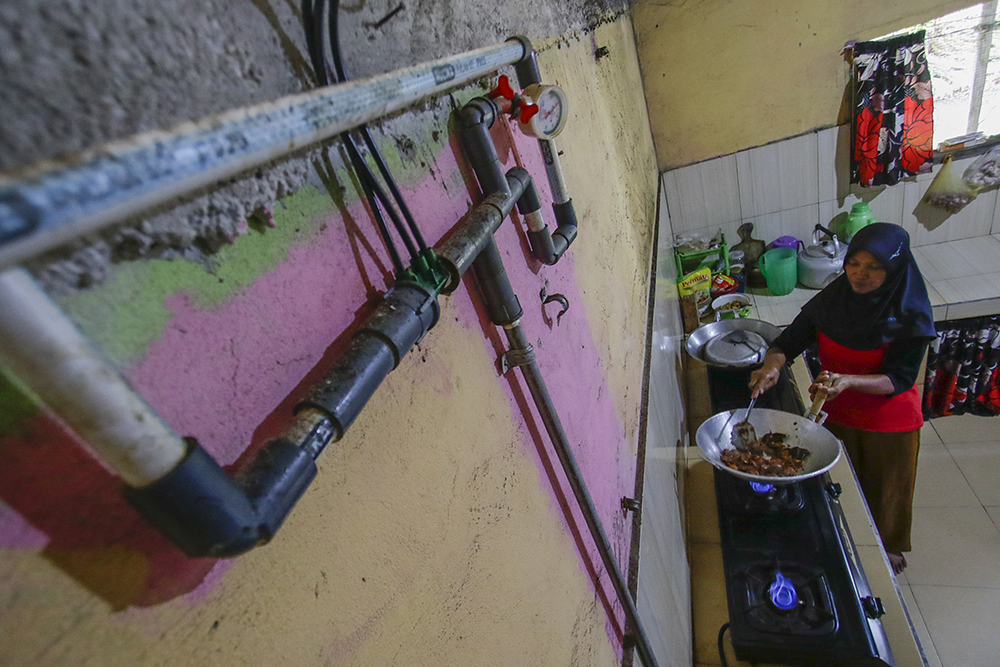 MEMASAK: Suramti, warga Desa Muktisari memasak di dapur rumah menggunakan Biogas, Tapung, Kampar, Riau, Sabtu (6/7/2024) Total kapasitas reaktor 165 meter kubik dengan total 21 sambungan biogas menjadikan Desa Muktisari yang terbesar dari 28 DEB di Indone