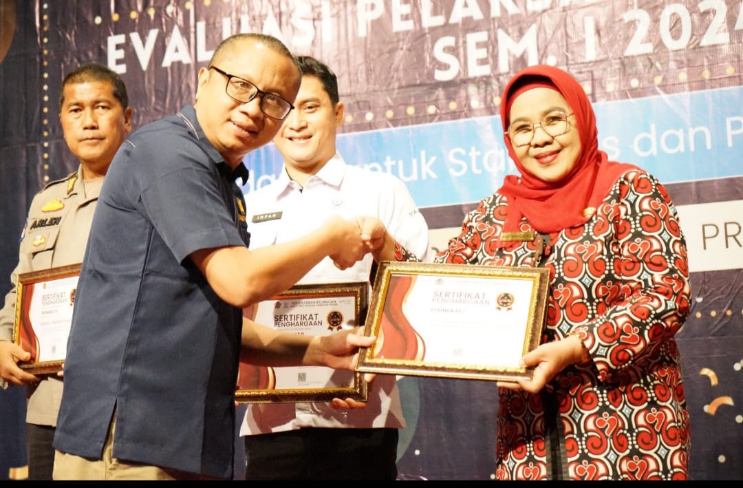 Kepala KPPN Pekanbaru Arif Khuzaini menyerahkan penghargaan kepada kepada Perwakilan BKKBN Riau Mardalena Wati Yulia pada acara Treasury Award di Hotel Primeere, Selasa (27/8/2024).