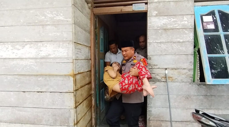 Kapolsek Perhentian Raja Ipda Riko Rizki Masri membawa anak disabilitas ke mobil ambulance untuk pemeriiksaan dan pengobatan di Rumah Sakit, Jumat (31/08/2024).