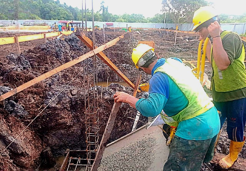 Aktivitas pekerja yang membangun Rumah Sakit Pratama Desa Penyagun di lokasi pembangunan, Jumat (30/8/2024) siang.