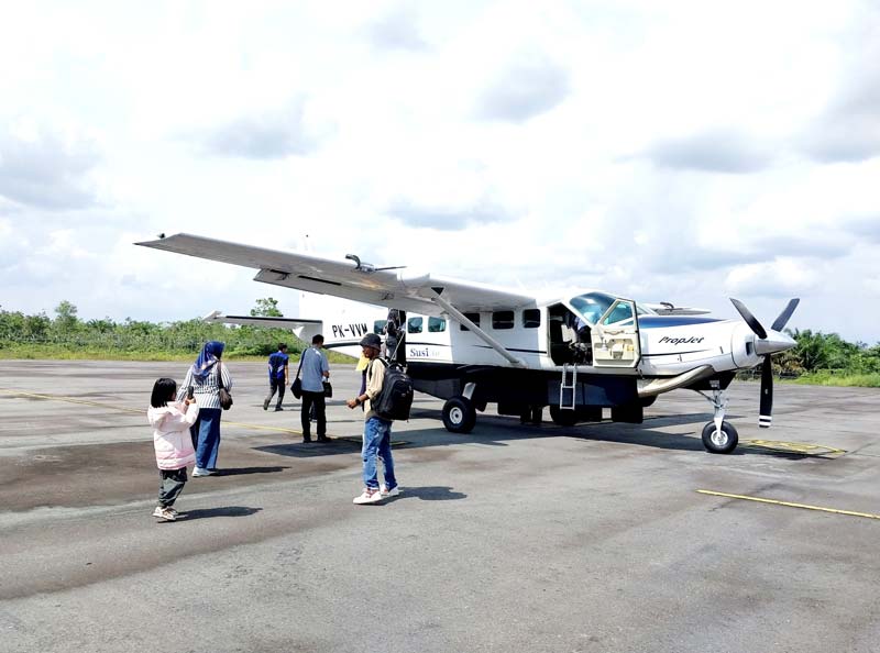 Sejumlah penumpang sedang berjalan menuju tangga pesawat perintis maskapai Susi Air yang melayani rute penerbangan Pasirpengaraian-Batam melalui Bandara Tuanku Tambusai, Pasirpengaraian, baru-baru ini