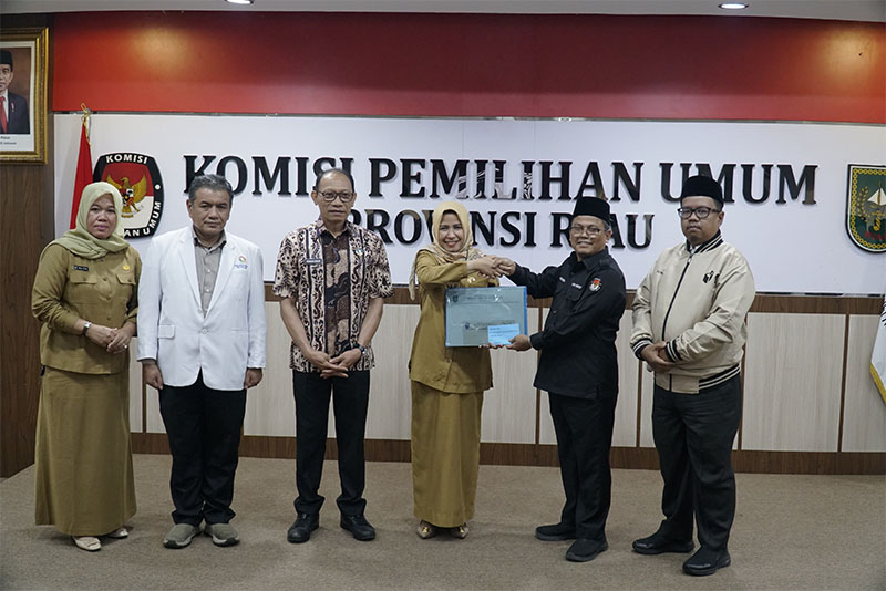 Dirut RSUD Arifin Ahmad, drg Wan Fajriatul Mam Nunah SpKG menyerahkan berkas pemeriksaan kesehatan para cakada kepada Ketua KPU Riau Rusidi Rusdan, Selasa (3/9/2024).