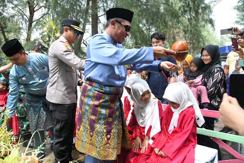 Wakil Bupati Bengkalis H Bagus Santoso mengguyurkan air&nbsp; ke sekujur tubuh beberapa anak-anak Pulau Rupat dengan menggunakan gayung yang terbuat dari tempurung kelapa.