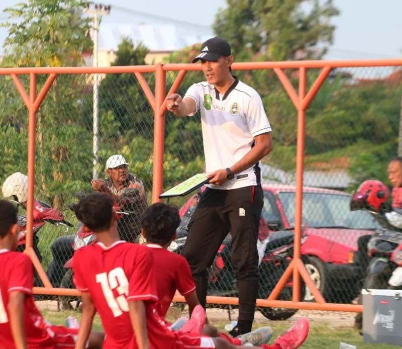 Pelatih Tim PON Riau Ambrizal memberi instruksi kepada pemain jelang pertandingan melawan Papua Pegunungan di Stadion Blang Paseh, Sigli, Rabu (4/9/2024).