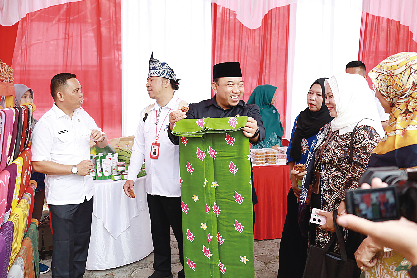 Wabup Siak Husni Merza memegang batik produksi pelaku UMKM Kampung Dayun,  Kecamatan Dayun, Kabupaten Siak, Rabu (4/9/2024)