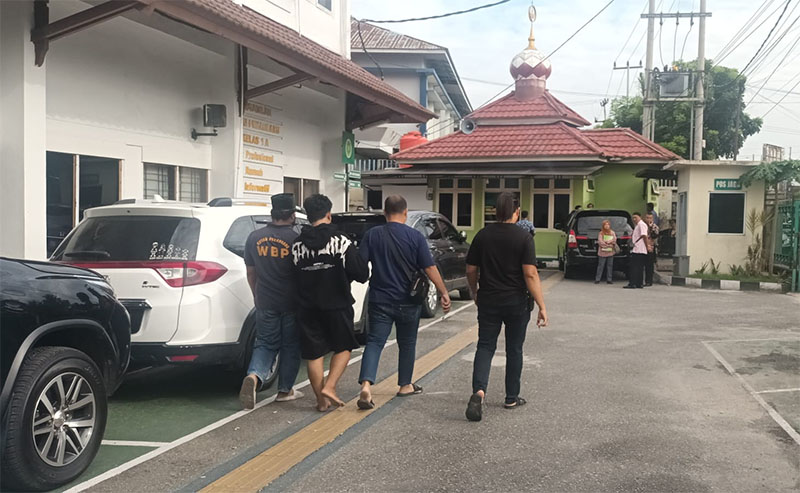 Terdakwa Am dan D (berurut dari kiri) saat digiring polisi berpakaian preman saat masih berada di PN Pekanbaru pada Selasa (10/9/2024).