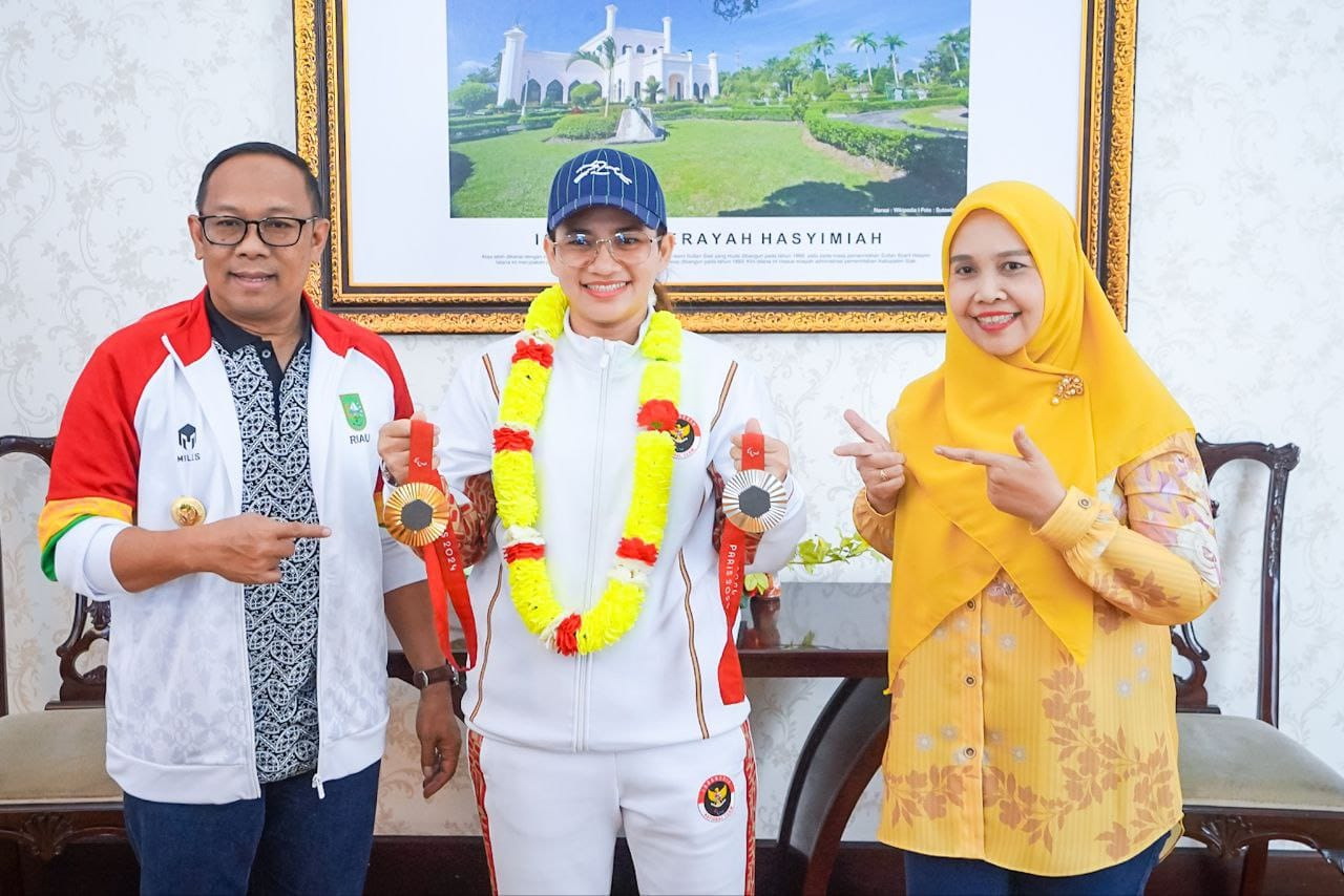 Pj Gubri Rahman Hadi foto bersama dengan peraih emas Paralimpiade Paris Leani Ratri di VIP Bandara SSK II Pekanbaru, Sabtu (14/9/2024).