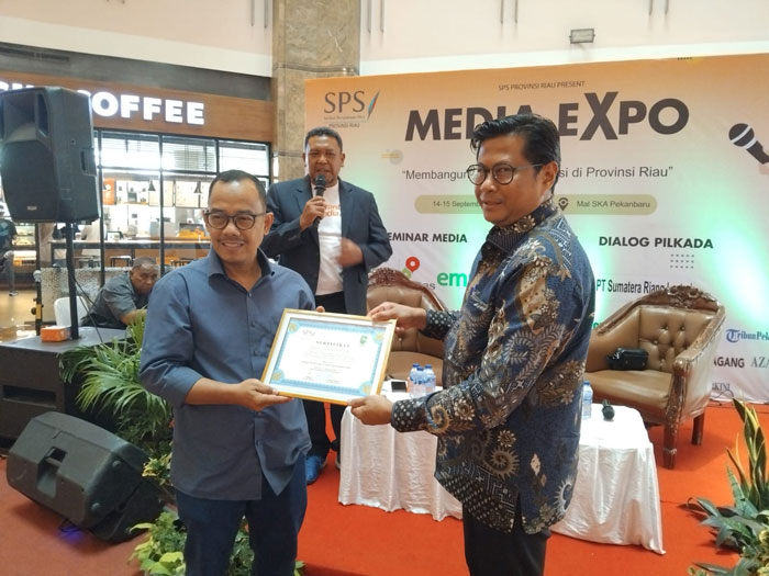 Corporate Secretary PT Bumi Siak Pusako (BSP) Ardian Ardi menerima sertifikat penghargaan dari Direktur Riau Pos Asmawi Ibrahim mewakili SPS Riau.