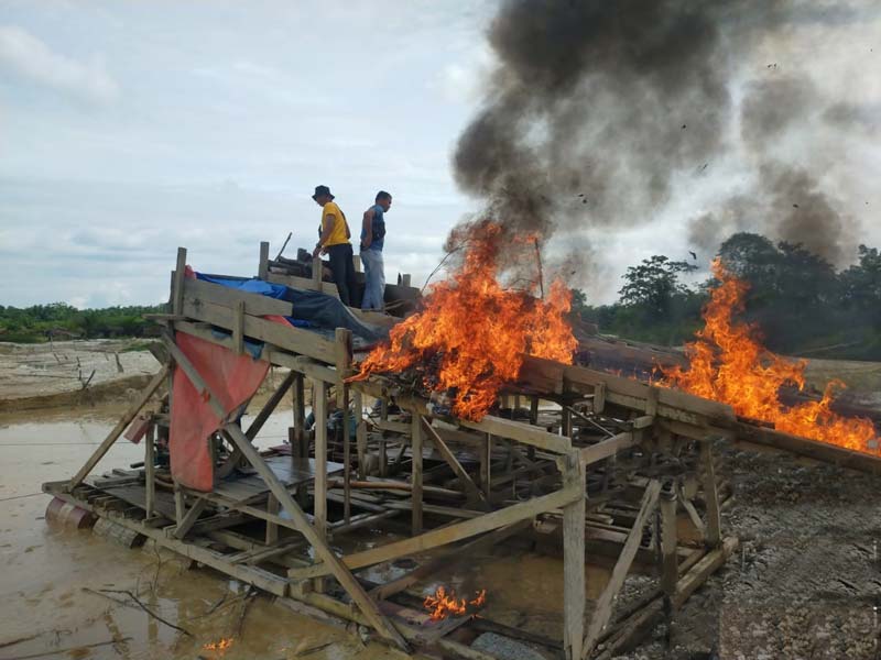 Rakit-rakit PETI dibakar personel Polsek Singingi Hilir saat melakukan operasi penertiban, Ahad (15/9/2024).