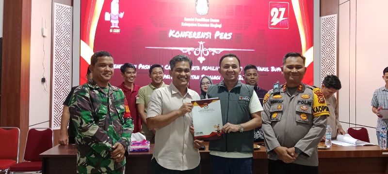 Ketua KPU Kuansing Wawan Ardi menyerahkan SK Penetapan Paslon pada Ketua Bawaslu Mardius Adi Saputra disaksikan Kapolres AKBP Pangucap Priyo Soegito, Danramil Kuantan Tengah,  Ahad (22/9/2024).