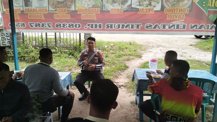 Personel Satlantas Polres Pelalawan saat berdialog dengan masyarakat di salah satu kedai kopi di Jalan Lintas Timur, Km 67, Kecamatan Pangkalan Kerinci, Kabupaten Pelalawan, Senin (23/9/2024).
