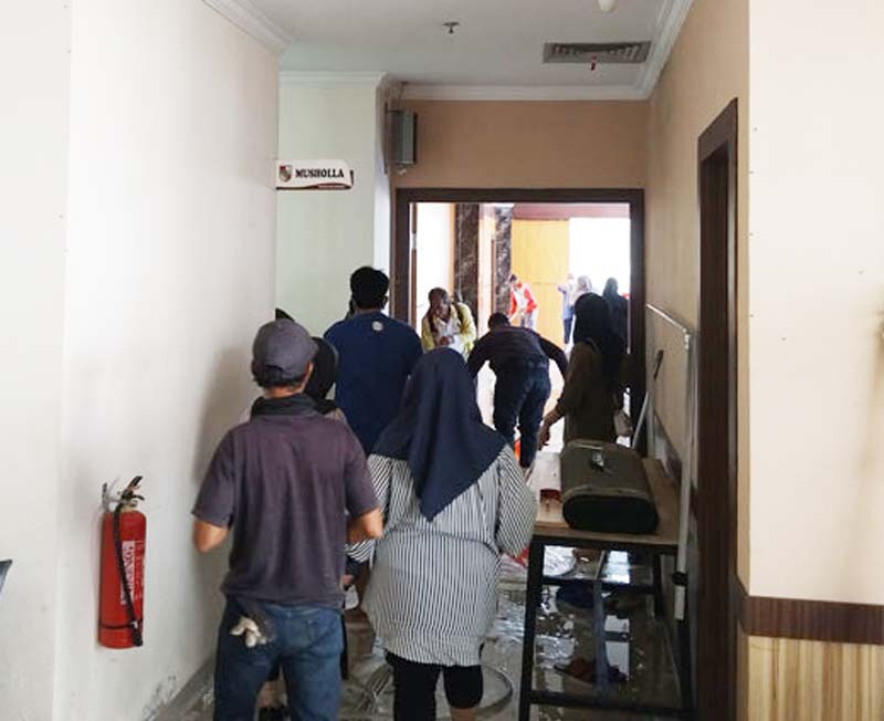Para ASN dan petugas kebersihan Dinas PUPR bergotong royong membersihkan gedung yang akan mereka tempati sementara waktu, Senin (23/9/2024).