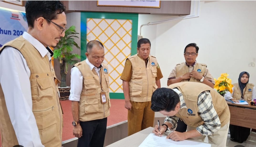 Kepala Balai Bahasa Provinsi Riau, Toha Machsum MAg (kiri), menyaksikan salah seorang peserta yang sedang menandatangani blanko rekomendasi pada acara Forum Konsultasi Publik Standar Pelayanan BBPR.
