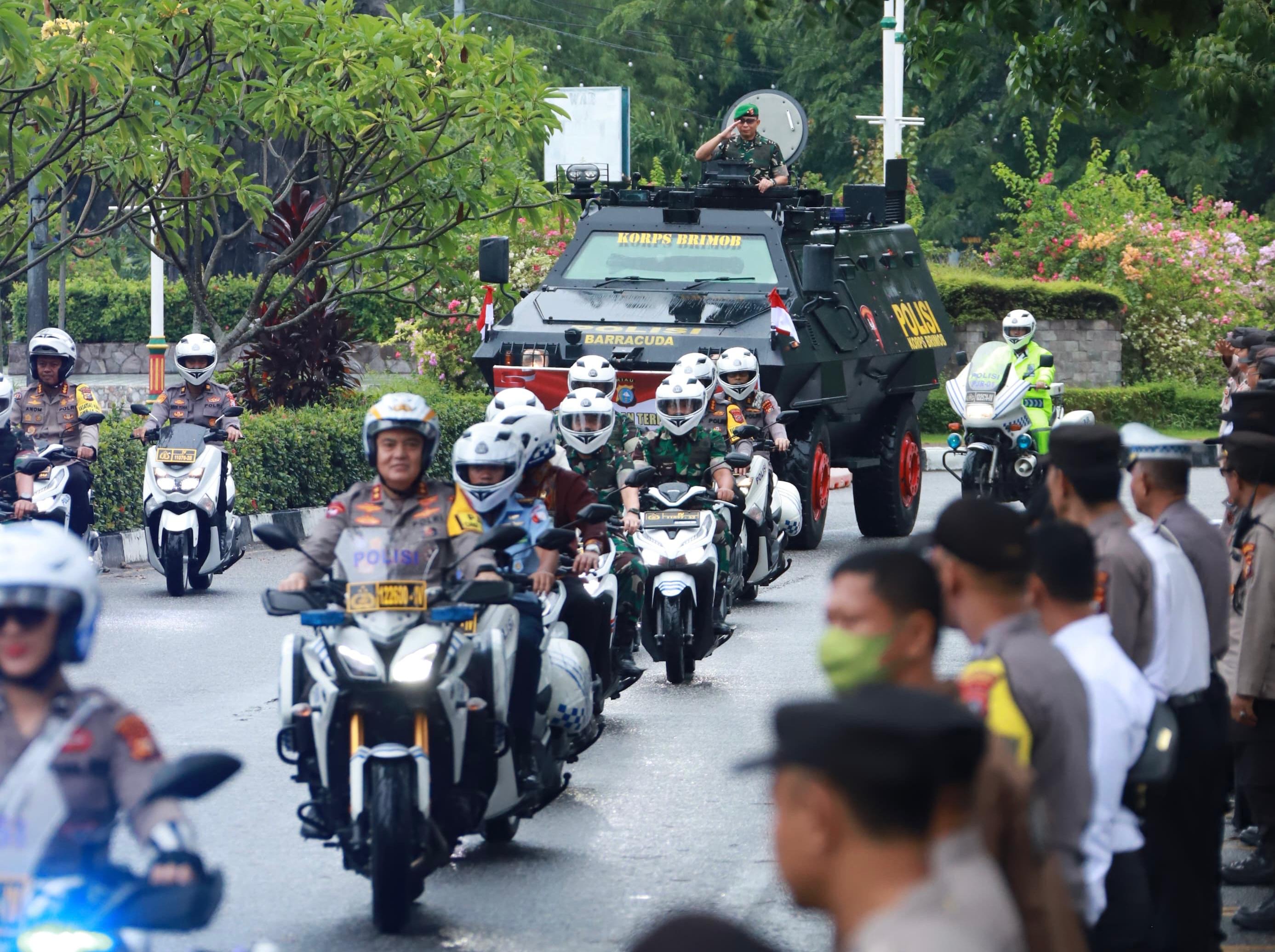 Brigjen TNI Dany Rakca Andalasawan berdiri hormat diatas rantis Baracuda Brimob saat diarak oleh Kapolda Riau Irjen Pol Mohammad Iqbal (menunggani motor) dalam upacara pelepasan jabatan Danrem 031/WB.