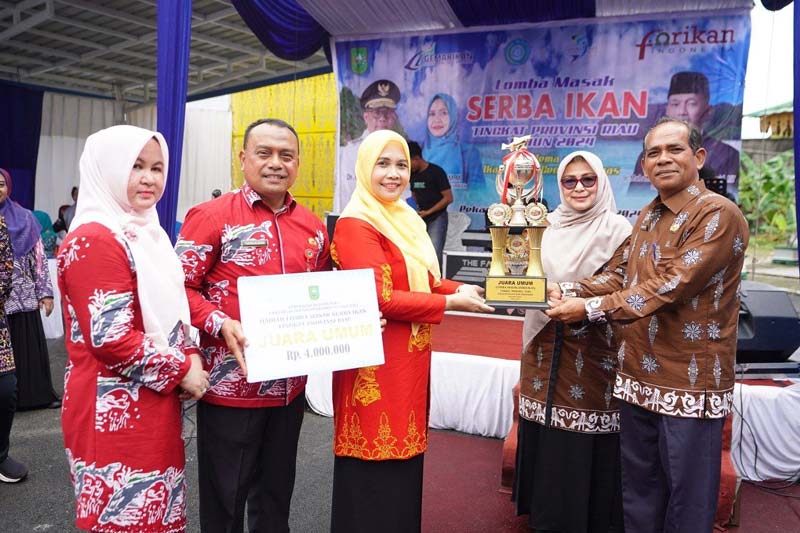 Pj Ketua TP PKK Riau Zuliana menyerahkan piala juara umum lomba masak serba ikan tingkat provinsi kepada TP PKK Siak, Kamis (26/9/2024).