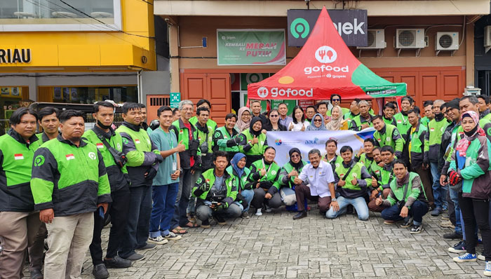 Pengurus Asosiasi Asuransi Umum Indonesia (AAUI) Pekanbaru berfoto bersama driver ojek online usai berbagi makanan dalam rangka menyambut hari asuransi