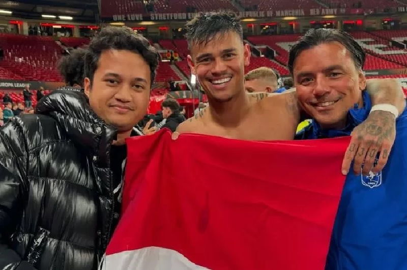 Mees Hilgers bersama Ananda Putra Hasanudin membentangkan bendera Indonesia di Stadion Old Trafford.