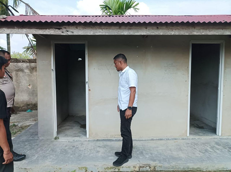PS Kanit IV Sakreskrim Polres Siak Aipda&nbsp;Leonar Pakpahan SH berada di depan toilet rumah ibadah mengecek lokasi korban NFN (13) dirudapaksa, Selasa (1/10/2024).
