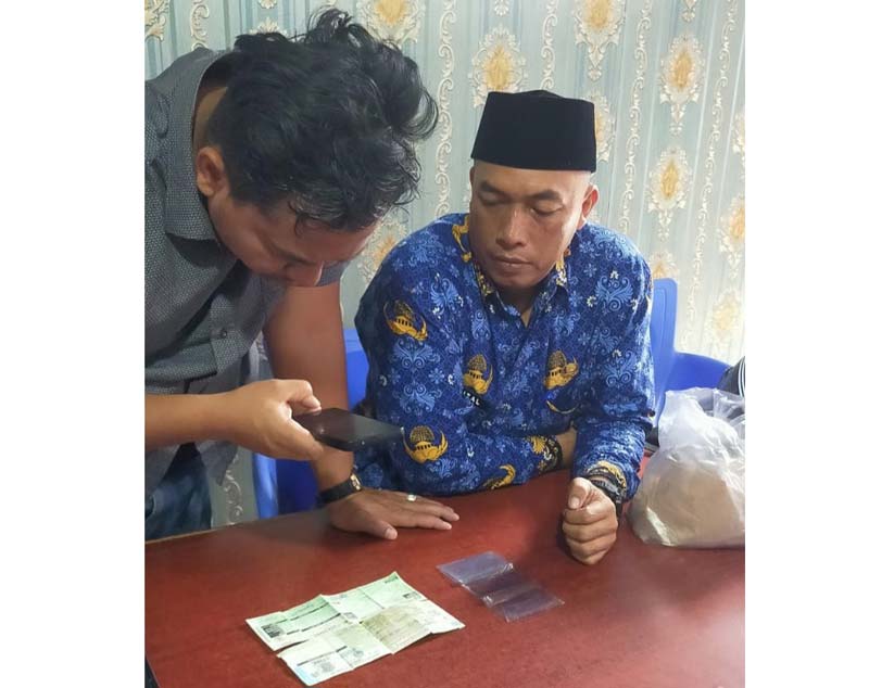 Kepala Bidang Pengembangan Perdagangan Disperindag Inhu Nurizal Murza Indra SSos MSi memandu salah seorang warga membuat QR code, Selasa (1/10/2024).