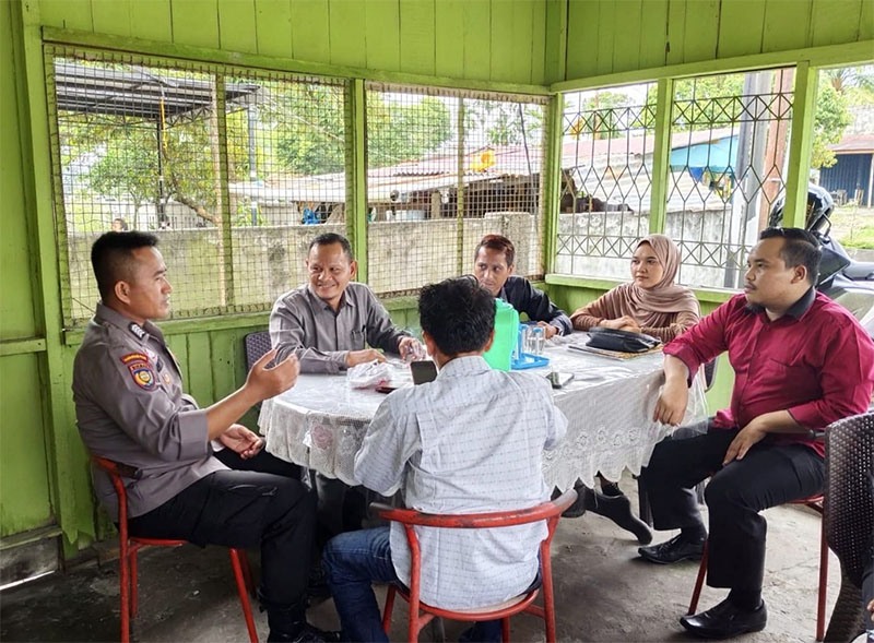 Ps Kanit Bhabinkamtibmas Sat Binmas Bripka Gondo Wahyu Utomo SH berdiskusi dengan sejumlah advokat menyampaikan pesan Pilkada Rohul Damai di salah satu warung di Pasirpengaraian, Rabu (2/10/2024).