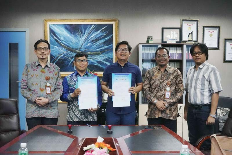 Direktur Utama Riau Pos Ahmad Dardiri (tengah) bersama Pejabat Pembuat Komitmen Zihamusholihin (dua kiri) memperlihatkan kontrak kerja sama yang sudah ditandatangani