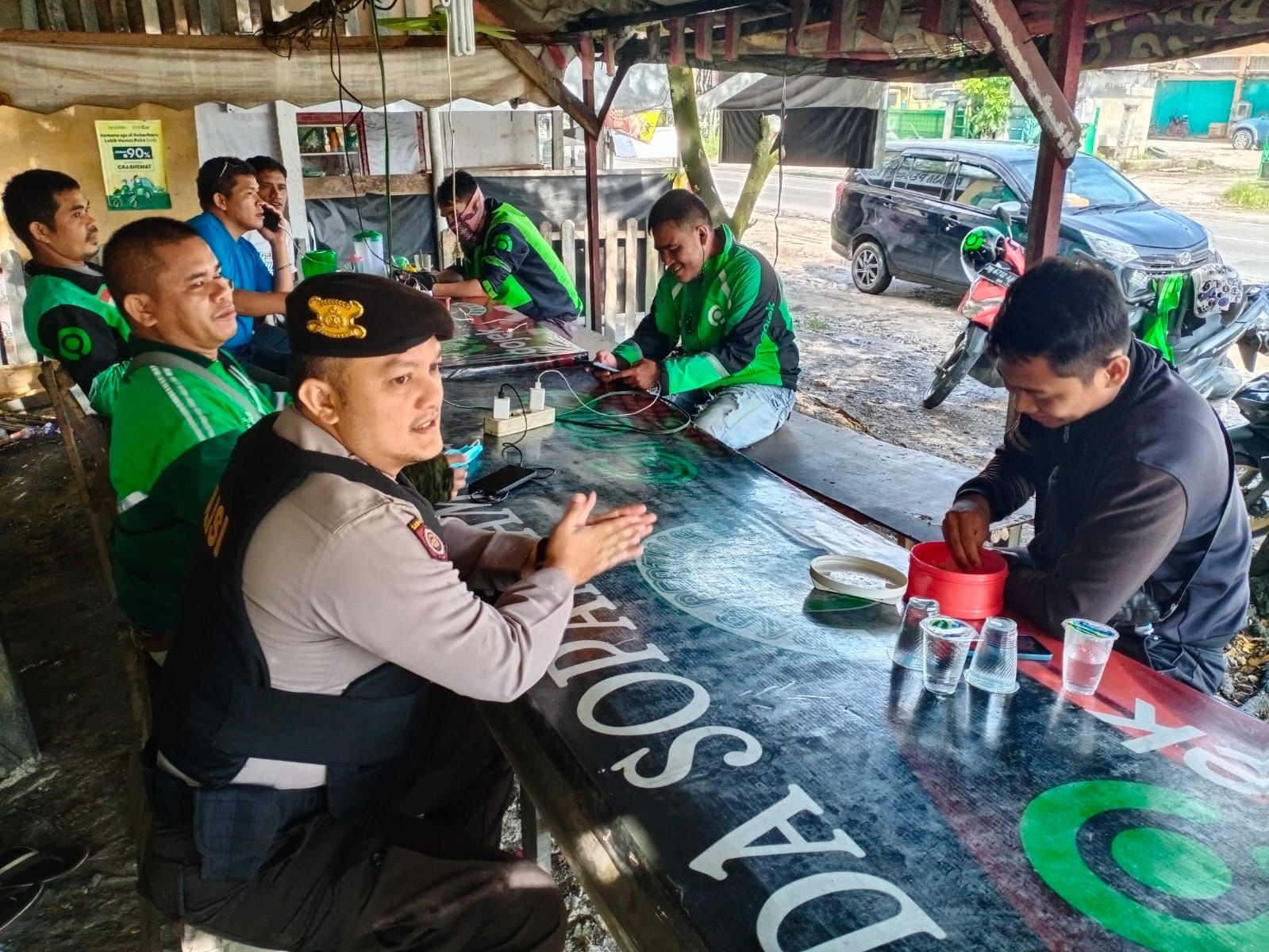 Anggota Sat Samapta Polresta Pekanbaru saat menyampaikan pesan pilkada damai kepada pengemudi Ojol, di salah satu pangkalan Ojol. Kamis (03/10/2024).
