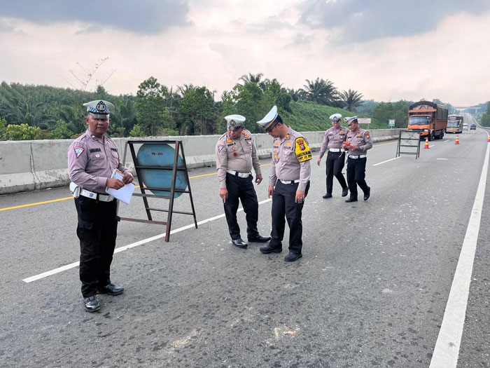 Petugas melakukan olah tempat kejadian perkara kecelakaan antara bus dan truk tronton di ruas Tol Pekanbaru-Dumai (Permai).