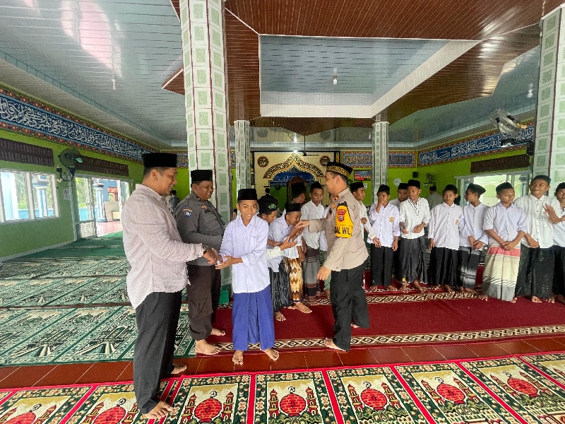 Kapolsek Siak Kecil Ipda Dr Eko Wahyu NB MH menyalami para santri usai Salat Jumat berjamaah di Masjid Al-Jami Desa Sungai Siput, Jumat (4/10/2024).