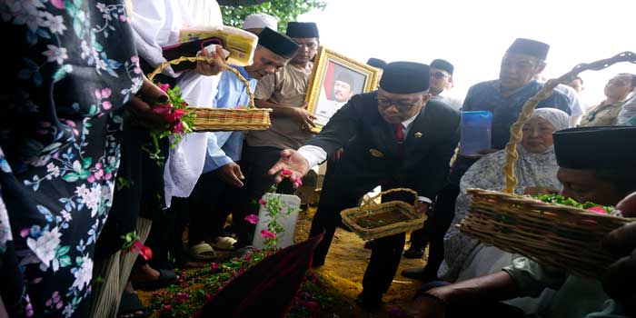 Pj Gubri Rahman Hadi menaburkan bunga saat proses pemakaman Kadisbud Riau Almarhum Raja Yoserizal Zen di TPU Gobah, Pekanbaru, Sabtu (5/10/2024).
