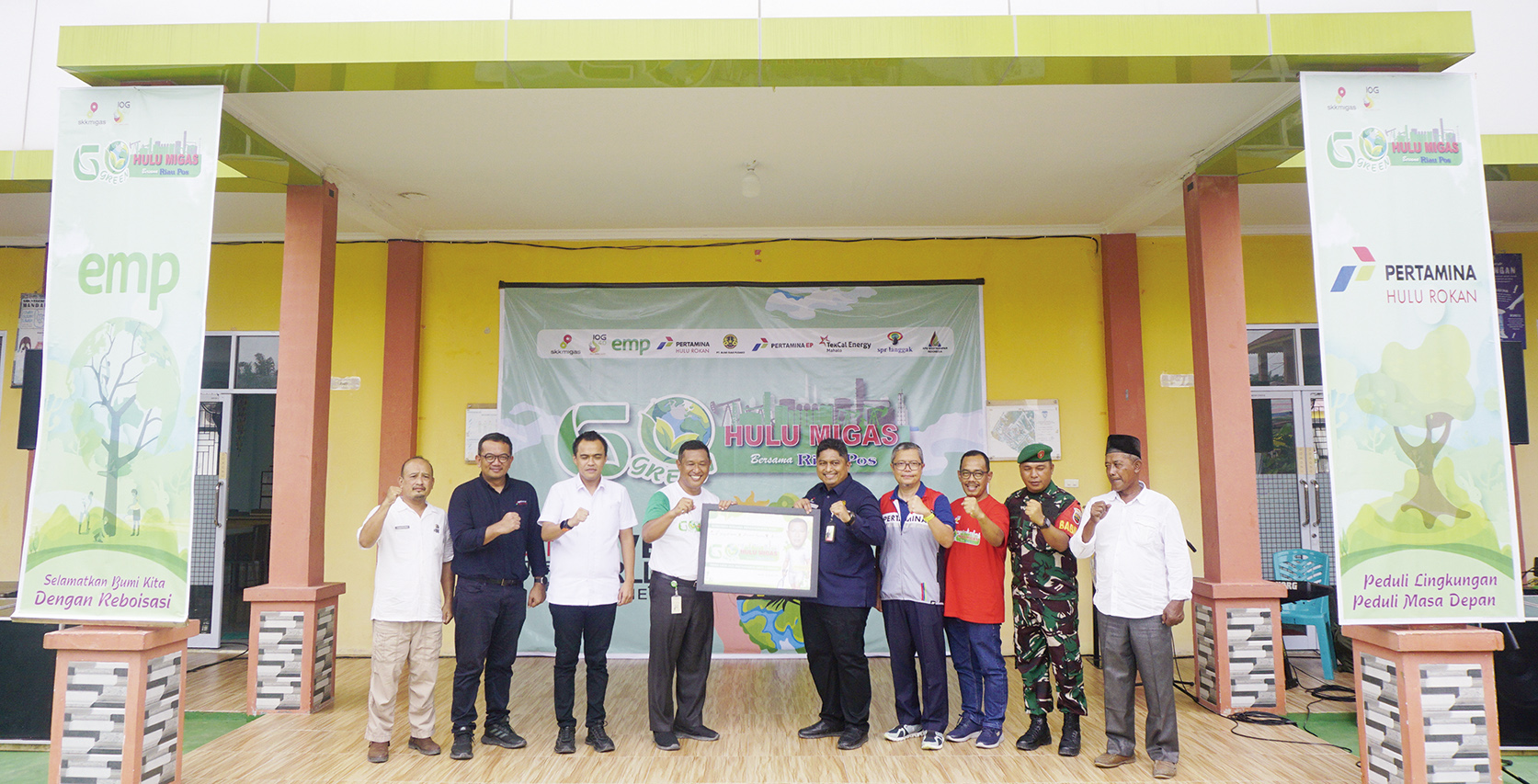 Koordinator Formalitas dan Komunikasi SKK Migas Sumbagut Muhammad Rochaddy (lima kanan) memberikan kenang-kenangan kepada Kepala SMKN 3 Mandau Agus Subagiyo (empat kanan) saat gelaran Go Green Hulu Migas Bersama Riau Pos 2024 di SMKN 3 Mandau, Bengkalis,