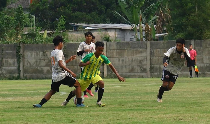 Pemain tim sepakbola Pra-Popnas Riau (temngah) melewati adangan pemain Persija Muda dalam laga uji coba melawan Persija Muda.
