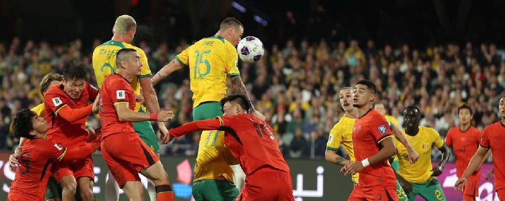 Pemain Austrlia (kuning) duel di udara dengan pemain Cina di Kualifikasi Piala Dunia 2026 Zona Asia Grup C. Australia menang 3-1 di laga itu.