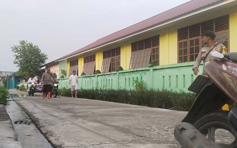 Personel kepolisian tampak mengecek lokasi banjir yang mulai mengering di Jalan Siak, Bagansiapiapi, Rokan Hilir, Ahad (13/10/2024).