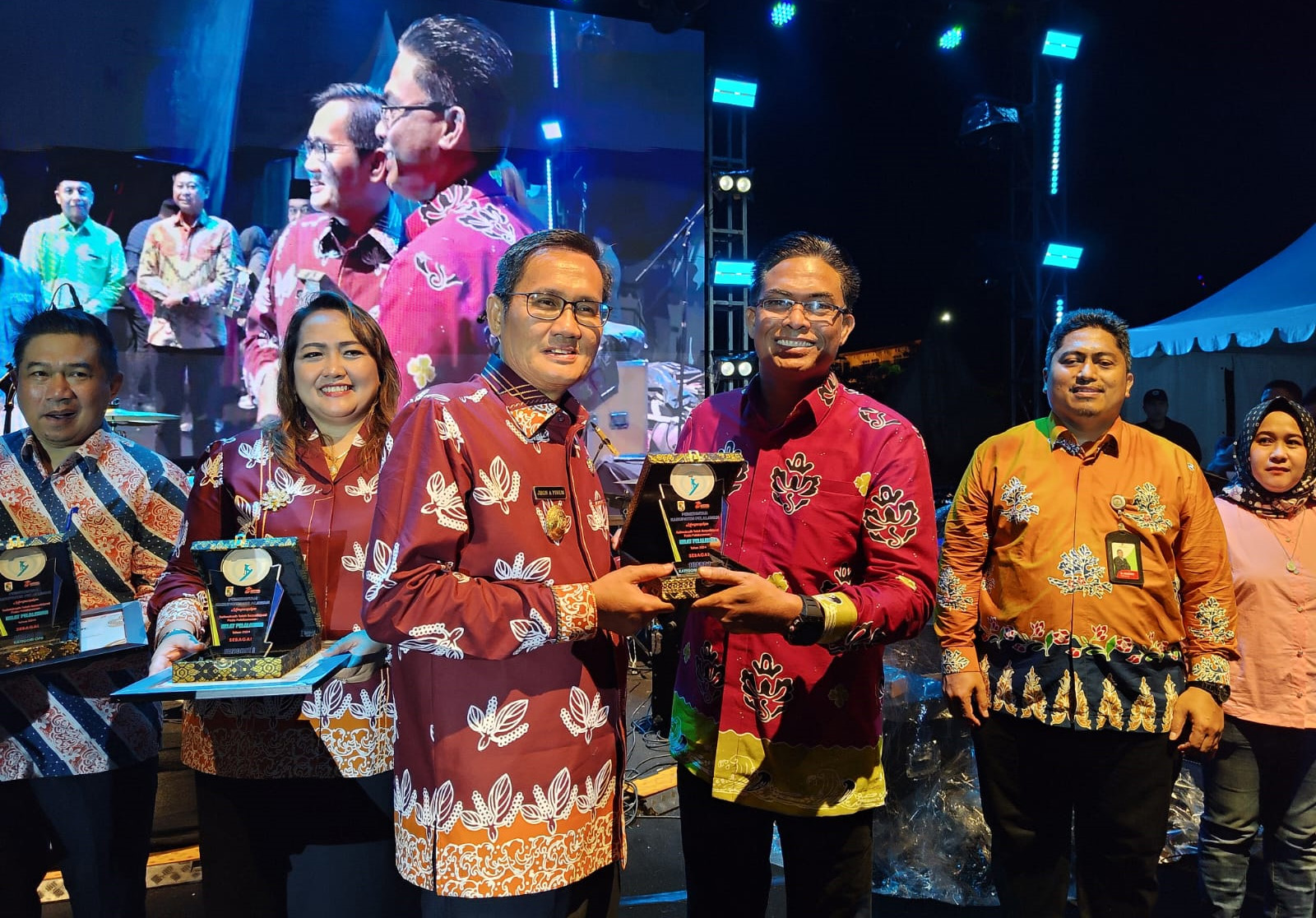 Penjabat (Pj) Bupati Pelalawan Dr.Jhon Armedi Pinem menyerahkan penghargaan Stand Terbaik Helat Pelalawan 2024 kepada RAPP dan APR, yang diterima oleh SHR Manager RAPP Mabrur.