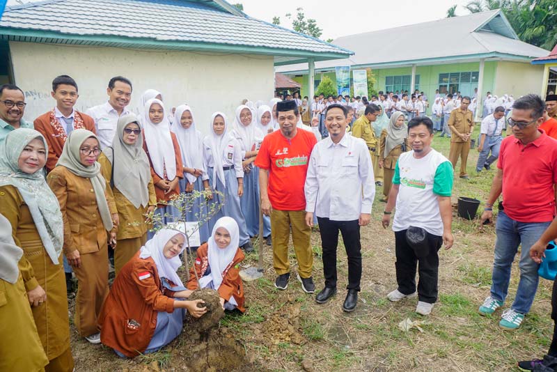 Ketua OSIS SMAN 1 Sungai Apit Wan Faiza Muthia menjadi perwakilan siswa saat melakukan penanaman pohon dalam kegiatan Go Green Hulu Migas bersama Riau Pos di SMAN 1 Sungai Apit,  Kabupaten Siak.