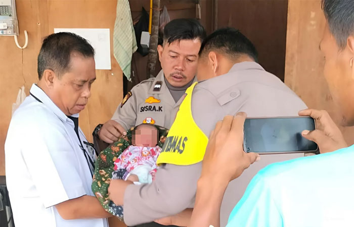 Personel Polsek Bukit Raya saat menjemput bayi perempuan berusia sekitar tiga hari, yang ditemukan di Jalan Pertambangan, Bukit Raya, Kota Pekanbaru pada Rabu (16/10/2024),