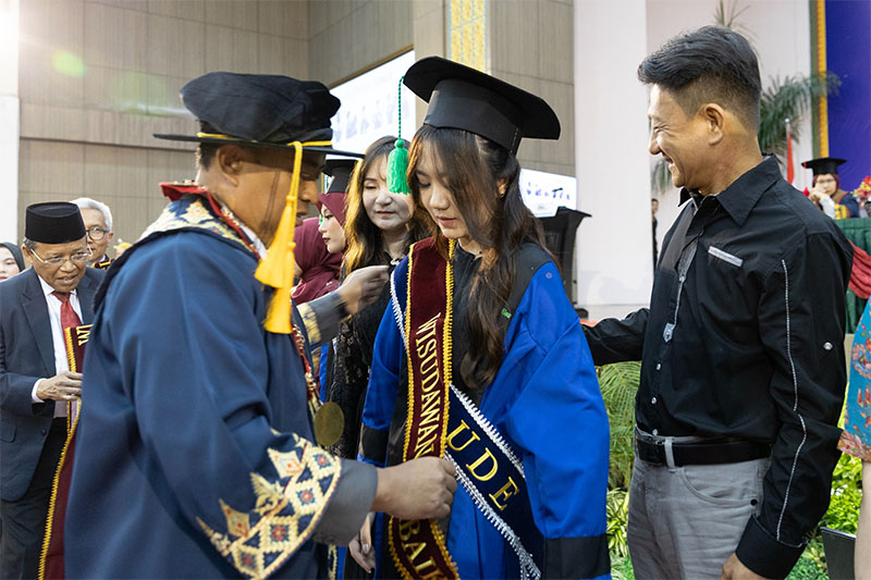 Direktur PCR Menyematkan Selempang Wisuda Terbaik kepada Wisudawan pada Pelaksanaan Wisuda XXI Politeknik Caltex Riau, Sabtu, 19 Oktober 2024.