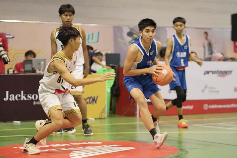 Pemain MAN 1 Pekanbaru Rafif Aidin Syahputra (biru) berusaha melewati adangan pemain SMA Santo Tarcisius Dumai saat pertandingan Honda DBL with Kopi Good Day 2024