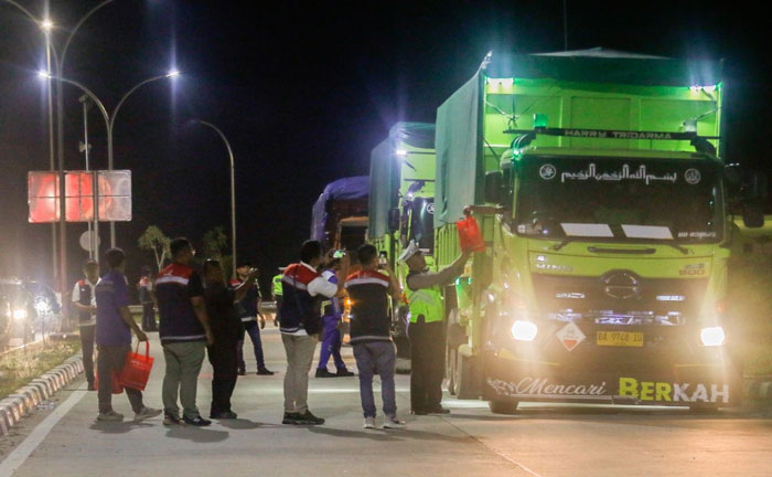 Personil Kepolisian dan Hutama Karya memberikan bingkisan dan kopi kepada pengendara angkutan barang saat gelar Operasi Micro Sleep di Tol Pekanbaru - Dumai (Permai), Sabtu (19/10/2024) dini hari.