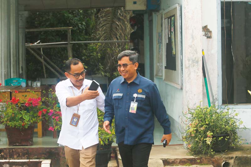 Direktur Riau Pos Asmawi Ibrahim (kiri) menyambut kedatangan  Kepala Departemen Humas SKK Migas Sumbagut Yanin Kholison.