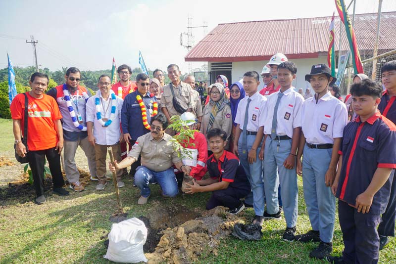 Perwakilan siswa Joshua Frenandes Hulu (kanan duduk) saat melakukan penanaman pohon, disaksikan tamu VIP dalam rangkaian Go Green Hulu Migas bersama Riau Pos di SMKTS YPL Lirik, Inhu.